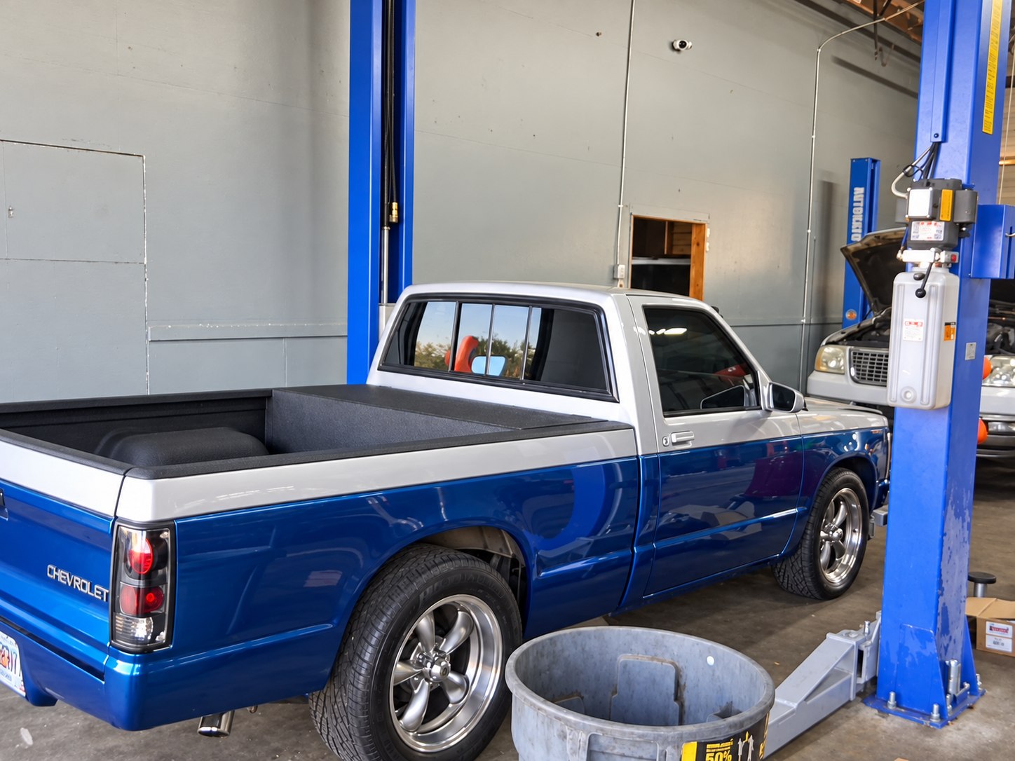 Blue and silver Chevrolet pickup inside a Khaos Automotive service bay